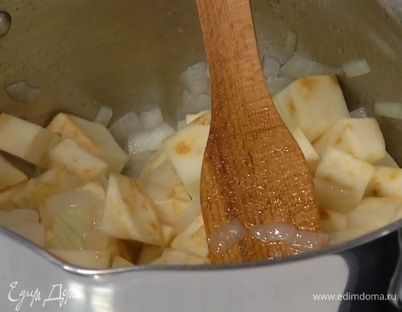 В кастрюле с тяжелым дном разогреть оливковое масло, выложить лук, слегка посолить и обжарить до мягкости, затем добавить корень сельдерея, еще раз посолить, и, помешивая, обжарить.