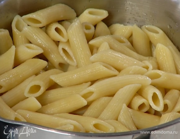 Пенне отваривать в подсоленной воде на 1 минуту меньше, чем указано на упаковке, затем, слив воду, добавить сливочное масло, 2 ст. ложки оливкового масла Extra Virgin и перемешать.