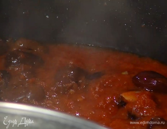 Разогреть в глубокой сковороде 1 1/2 ст. ложки оливкового масла и обжарить чеснок, выложить протертые помидоры, томатную пасту и оливки, все слегка посолить и, помешивая, прогревать на небольшом огне, затем добавить аджику, паприку и перемешать.