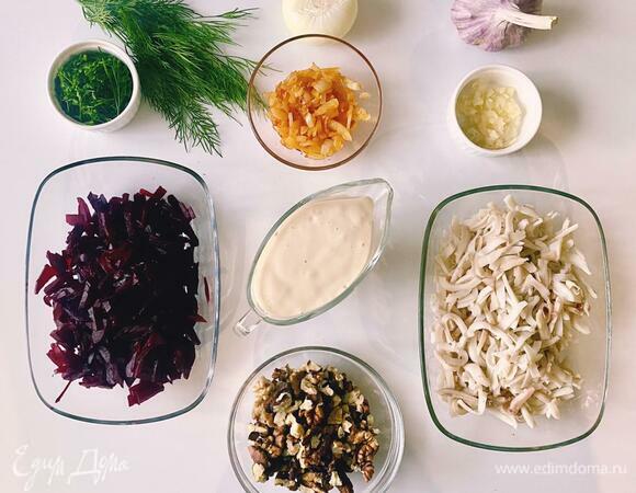 Мелко нарезанную луковицу обжарить в растопленном масле до золотистого цвета. Вареную свеклу натереть на крупной терке или нарезать соломкой — как больше нравится. Кальмары вымыть, почистить и варить в подсоленной (кидать в кипящую воду!) воде 3 минуты, не больше. Остуженные кальмары нарезать соломкой. Чеснок мелко нарезать или пропустить через пресс. Зелень мелко нарезать. Грецкие орехи помыть, подсушить в духовке и крупно нарезать.