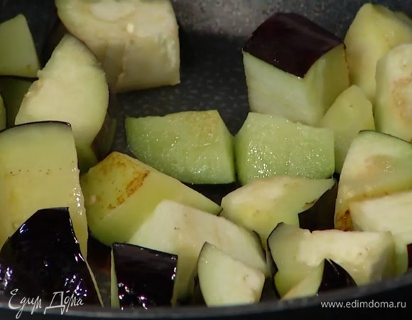 Разогреть в сковороде вок половину растительного масла, обжарить баклажаны до готовности и переложить в глубокую миску.