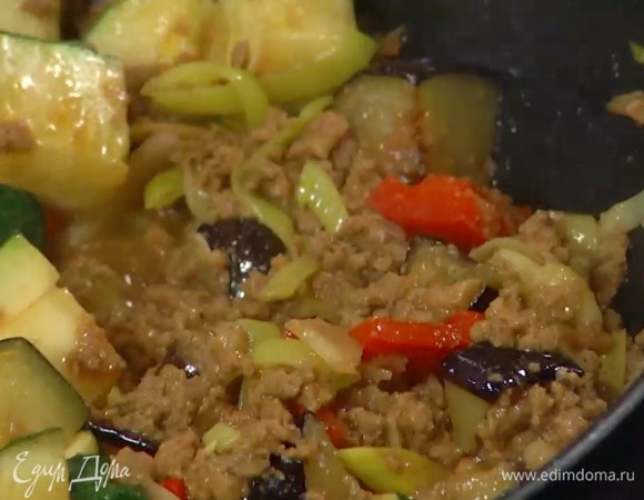В сковороду вок влить оставшееся растительное масло, выложить сладкий перец, имбирь, порей, чеснок, все перемешать и обжарить, затем добавить цукини, посолить, выложить в вок фарш и, помешивая, обжарить до готовности.