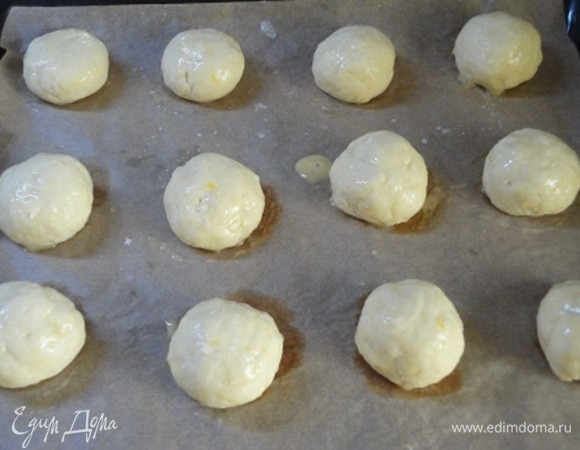 Делим на кусочки (не более 40 г каждый) и формируем шарики. Выкладываем их на противень. По желанию тесто можно слегка прижать сверху и смазать желтком.