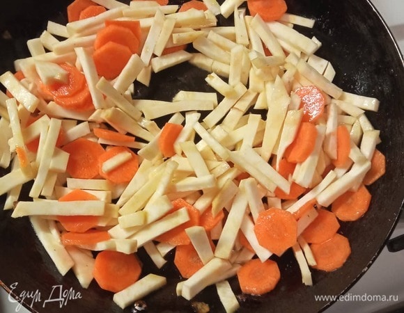 Нарезать морковь кружочками, а корень сельдерея — брусочками. Обжарить на другой сковороде в масле 3 минуты. Добавить нашинкованный зеленый лук.