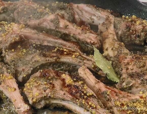 Перевернуть ребрышки, полить вином с горчицей и жарить до готовности.