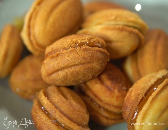 Оставшееся печенье наполнить сгущенкой, вложить внутрь миндальный орех и тоже соединить половинки.