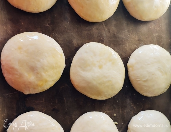 Каждый шарик раскатать до толщины примерно 2 см. Оставить на подъем на 30 минут. Смазать смесью желтка и молока, выпекать 25 минут при температуре 200°C.