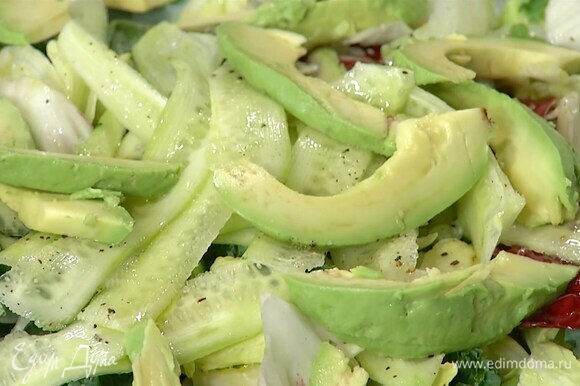 Авокадо почистить и удалить косточку, мякоть нарезать ломтиками и выложить на салат.