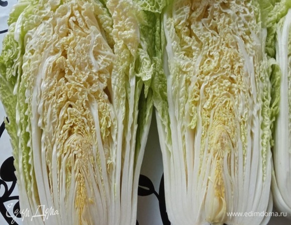 Кочаны пекинской капусты очистите от пожухлых листьев и разрежьте пополам. Затем вырежьте маленький треугольник у кочерыжки (самую твердую середину, иначе кочан развалится). После этого сделайте маленький вертикальный разрез вдоль. 