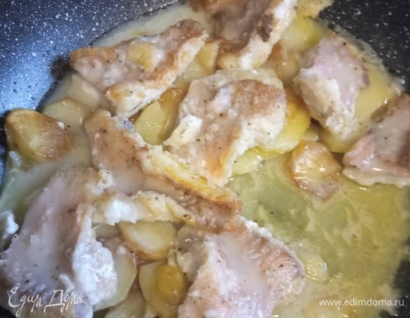 Залить соусом. Дать закипеть, накрыть крышкой и тушить на медленном огне 10 минут. Тем временем нарезать лук тонкими кольцами, чуть-чуть посыпать мукой и обжарить пару минут в раскаленном масле на другой сковороде.