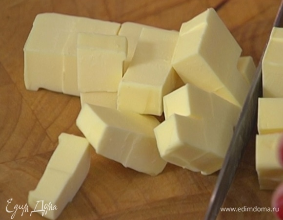 Предварительно охлажденное сливочное масло нарезать кубиками.