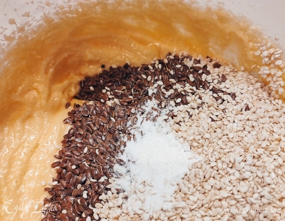 В масляную массу добавить по одному яйцу, каждый раз взбивая. Добавить семена льна и кунжут, разрыхлитель, ванилин. Хорошо перемешать.