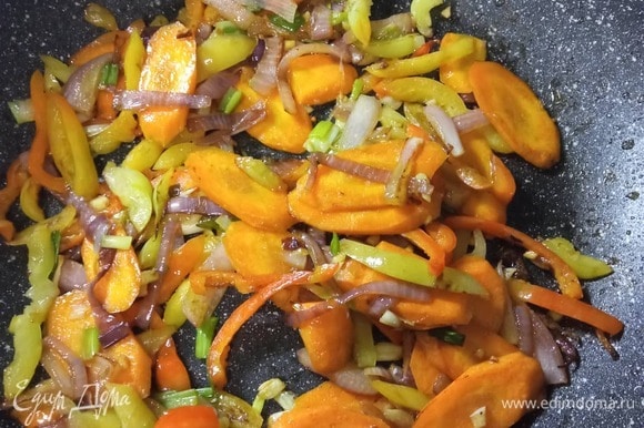 В том же растительном масле обжарить лук 2 минуты, добавить морковь. Обжаривать, постоянно помешивая, 2 минуты, добавить перец, жарить еще 2 минуты. Добавить чеснок и зеленый лук. По необходимости добавлять масло.