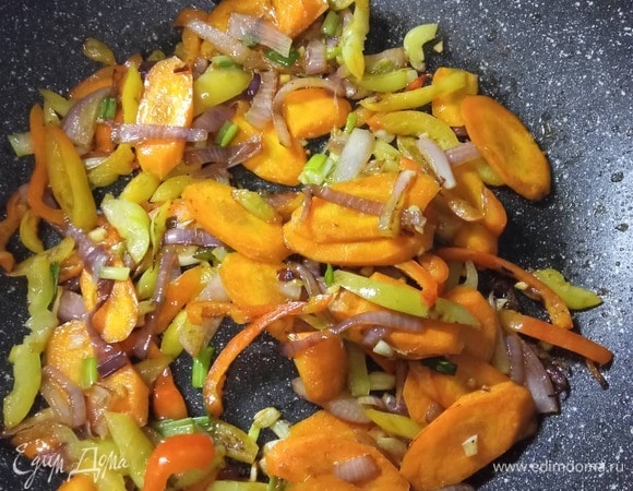 В том же растительном масле обжарить лук 2 минуты, добавить морковь. Обжаривать, постоянно помешивая, 2 минуты, добавить перец, жарить еще 2 минуты. Добавить чеснок и зеленый лук. По необходимости добавлять масло.