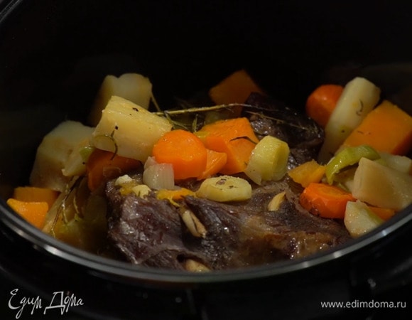 В чашу мультиварки выложить часть подготовленных овощей и измельченный чеснок, сверху поместить мясо и оставшиеся овощи, посолить, поперчить, добавить нарезанное маленькими кусочками сливочное масло, полить все вином, затем закрыть крышку и томить мясо с овощами до готовности.