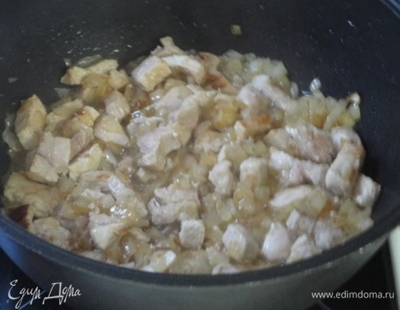 В сотейнике разогреть половину растительного масла. Обжарить лук с чесноком до золотистого цвета. Добавить мясо и продолжать жарить на сильном огне еще 4–5 минут.