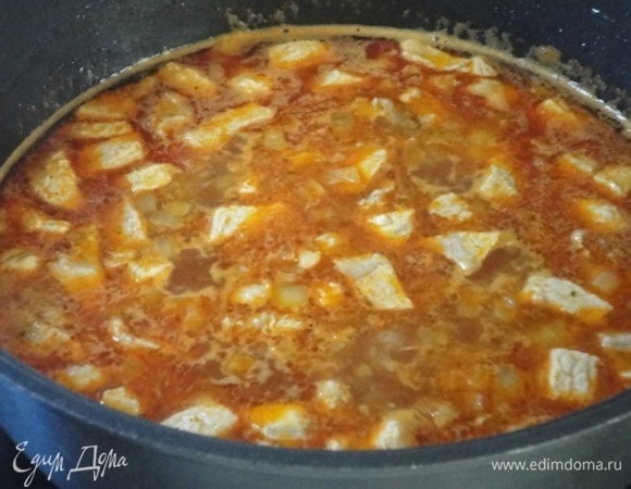 Добавить паприку и томатную пасту, посолить, влить мясной бульон и тушить на среднем огне 20 минут.