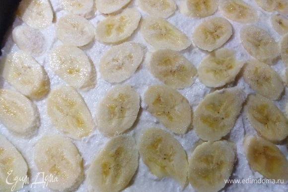 Форму смазать сливочным или топленым маслом. Выложить творожную массу. Сверху выложить нарезанный банан. Посыпать оставшимся сахаром. Поставить в разогретую духовку.