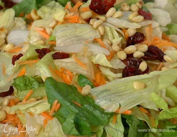 В глубокую посуду выложить салатные листья, посыпать клюквой и орехами, полить заправкой и перемешать.