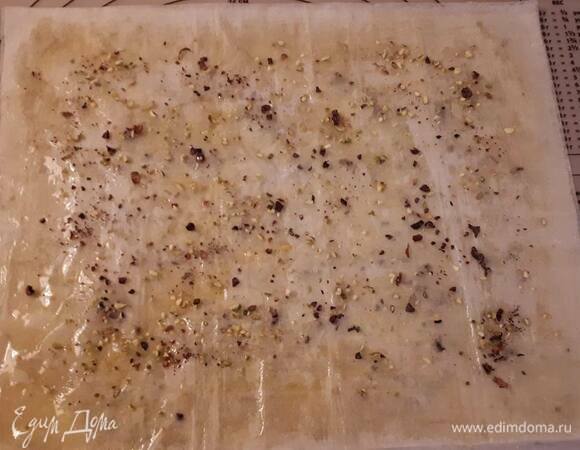 Смажьте лист фило растопленным маслом и посыпьте фисташками. Затем накройте следующим листом, смажьте маслом и так по очереди.