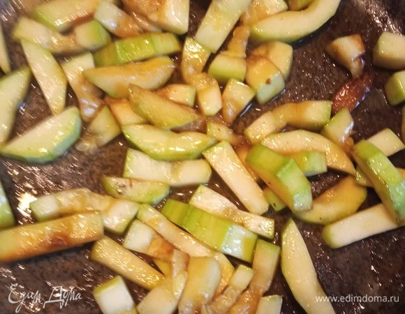 В другой сковороде обжарить мелко нарезанный лук и чеснок 2 минуты, добавить цукини, обжаривать 2 минуты. Посолить.