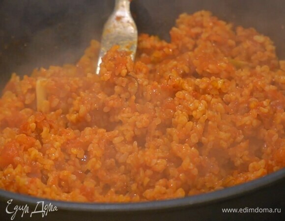 Добавить томатную пасту, помидоры в собственном соку, перемешать, влить горячий куриный бульон, накрыть крышкой и довести до готовности.