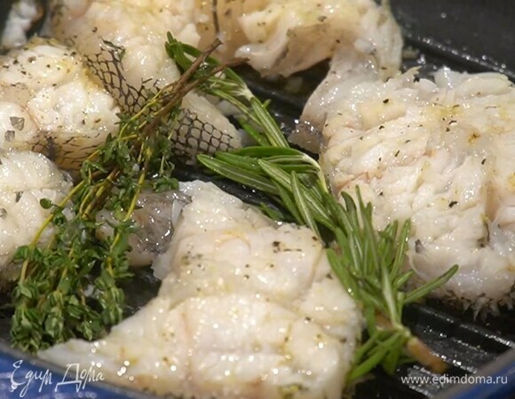 Стейки полить оливковым маслом, посолить, поперчить с двух сторон и обжаривать на разогретой сковороде-гриль с каждой стороны по 2 минуты, в конце выложить к рыбе веточки розмарина и тимьяна.