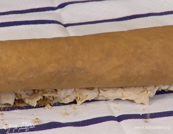 На расстеленное полотенце поместить бумагу для выпечки и перевернуть на нее выпеченную меренгу, затем снять бумагу, на которой выпекалась меренга, и с помощью нижней бумаги и полотенца свернуть все в рулет и полностью остудить.