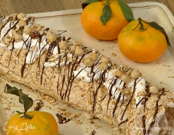 Развернуть остывший рулет, разложить дольки мандаринов, смазать кремом и снова свернуть в рулет. Покрыть сверху оставшимся кремом, посыпать измельченными орехами, украсить растопленным шоколадом и целым фундуком.