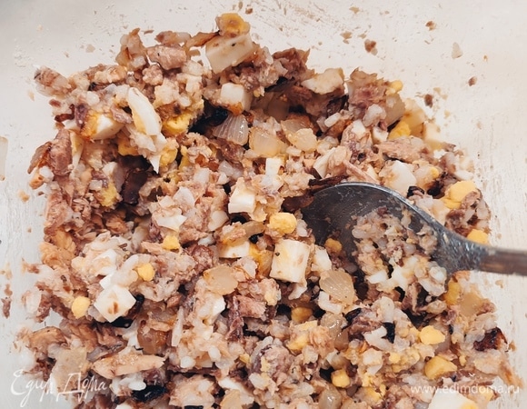 Для начинки лук мелко нарезать и обжарить до золотистого цвета. Яйца отварить и мелко нарезать. С сардин слить масло и размять. Все смешать.