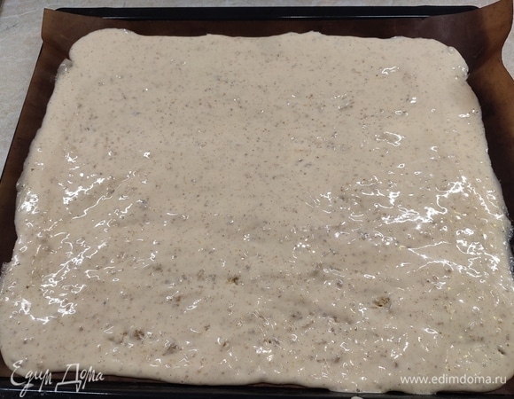 Орехи мелко смолоть, смешать с мукой и разрыхлителем, а затем аккуратно ввести в яичную смесь. После этого вылить тесто на противень и выпекать 12 минут при температуре 180°C. Затем освободить корж от пергамента и полностью его охладить.