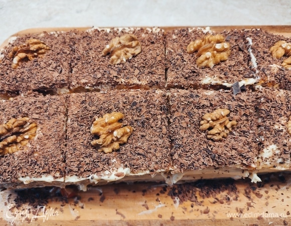 Разрезать готовый десерт на порции, посыпать тертым шоколадом и украсить грецким орехом.