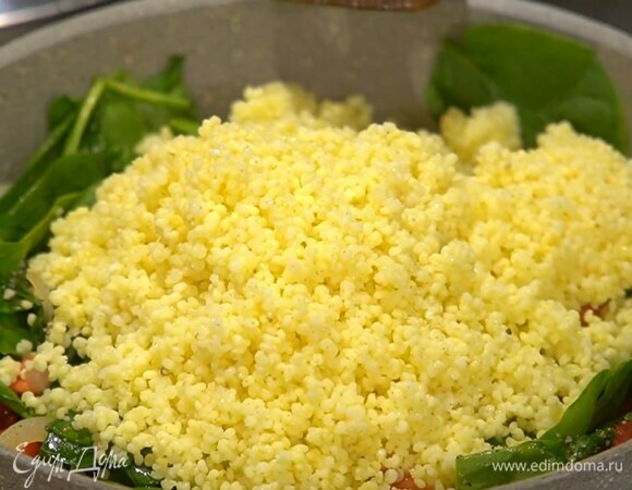 Помидор нарезать кубиками, добавить в сковороду, все перемешать, посолить, поперчить, посыпать пряной смесью и дать шпинату привять, затем добавить готовое пшено и еще раз перемешать.