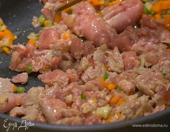 Колбаски надрезать вдоль и освободить от оболочки, выложить фарш в сковороду с овощами и размять лопаткой, затем добавить помидоры в собственном соку и прогревать все до готовности мяса.