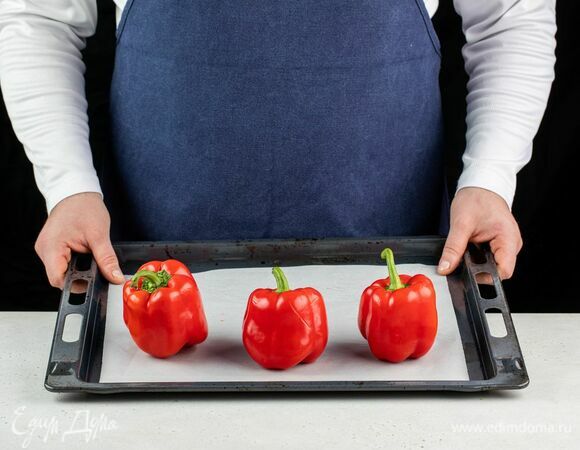Выложите перцы на противень и поставьте в разогретую до 180°С духовку на 15 минут.