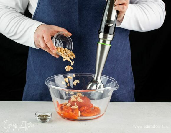 Овощи остудите, снимите кожуру с помидоров и перца. В чашу блендера выложите запеченные овощи, кешью, сушеный базилик.