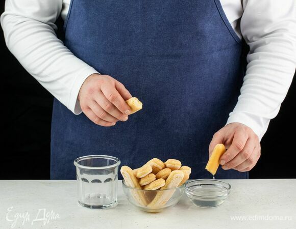 Первым слоем выложите в стакан для десерта кусочки печенья, смоченные в ананасовом сиропе.