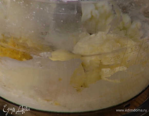 Предварительно размягченное сливочное масло и 80 г сахарной пудры слегка взбить в блендере, добавить отварные яичные желтки, цедру и взбить все в однородную массу, затем всыпать соль.