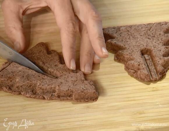 Отщипывать от теста кусочки и с помощью мультипекаря выпекать печенье в форме елочек, затем вырезать небольшие выемки и скрепить два печенья так, чтобы получились четырехгранные елочки.