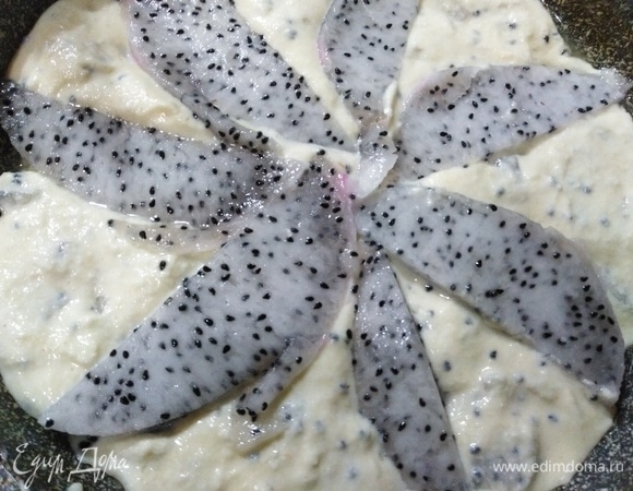 Выложить тесто в смазанную форму. Вторую половину фрукта нарезать дольками, выложить поверх теста. Поставить в разогретую духовку.