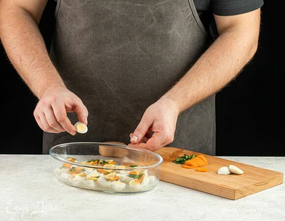 Когда бульон в форме застынет, выложите на первый слой кусочки судака, морковь, перепелиные яйца, листочки петрушки, дольки лимона.