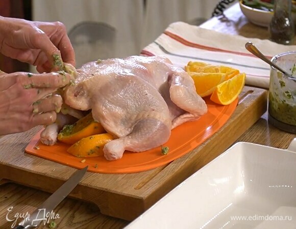 Тушку курицы вымыть, просушить, смазать внутри пряной заправкой и выложить туда несколько долек апельсина.