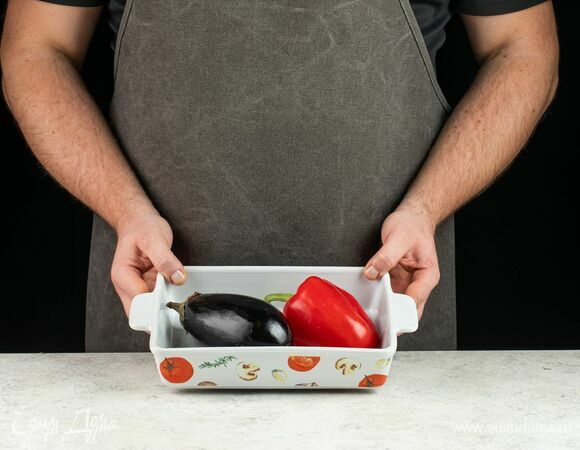 Баклажаны, болгарский перец и помидоры промойте и обсушите. Баклажаны проткните в нескольких местах вилкой. Положите на противень баклажаны и болгарский перец и запеките до мягкости в течение 20 минут при 200°С.