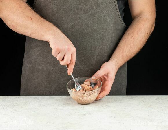 С консервированного тунца слейте жидкость и немного разомните рыбу вилкой.