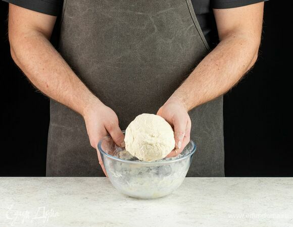 Вымесите тесто, положите его в большую миску, накройте полотенцем и поставьте в теплое место на расстойку на 1,5 часа. По истечении 40 минут обомните тесто и снова верните на расстойку.