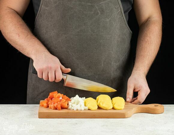 Филе горбуши нарежьте на кусочки, картофель нарежьте тонкими кружочками, все слегка посолите. Также измельчите лук.