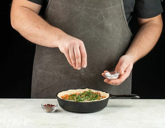 Свержу на картофель поместите обжаренный лук. Далее выложите кусочки рыбы и зелень, посолите.