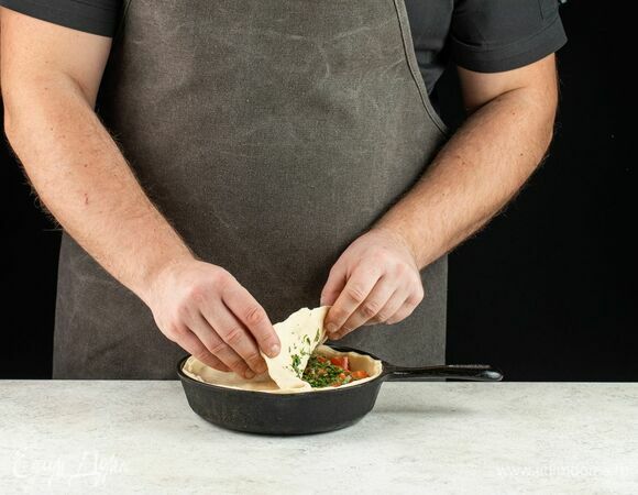 Раскатайте вторую часть теста в пласт и накройте им начинку. Защипните тесто по краю.