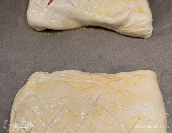 Далее выкладываем рыбу, солим и перчим ее по вкусу. Закрываем свободной от начинки частью теста, защипываем края. Я их немного подогнула вниз. Делаем небольшие надрезы на тесте, смазываем взбитым яйцом, посыпаем кунжутом.