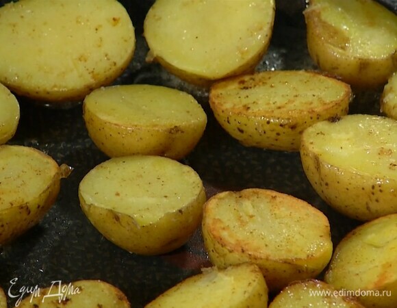 Картофель отварить в мундире, затем, не очищая, разрезать пополам и выложить срезами вниз на сковороду, где жарились грудки, посолить и обжаривать до появления золотистой корочки.